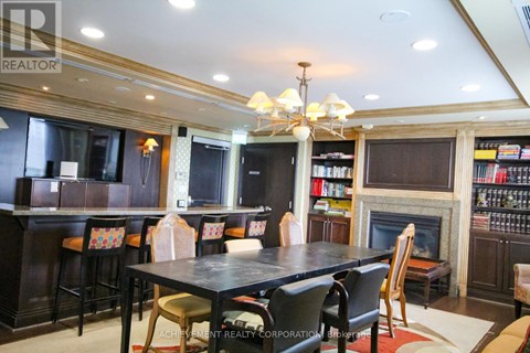 A dining room with a fireplace and a bookshelf.