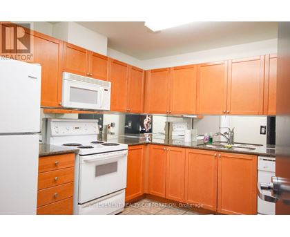 A kitchen with orange cabinets and a white fridge.