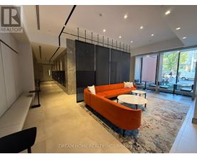 A modern living room with a black and orange sofa.