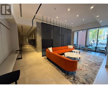 A modern living room with a black and orange sofa.