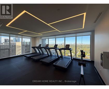 A gym with treadmills and a view of the city.