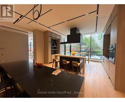 A modern kitchen with a black table and wooden cabinets.