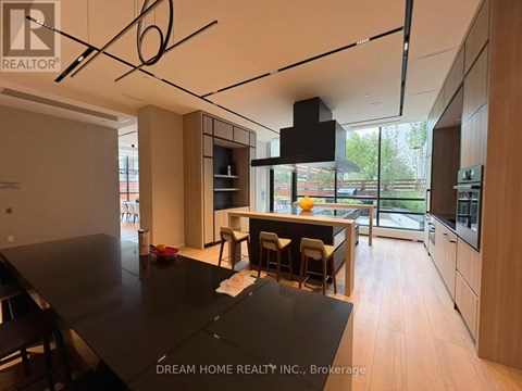 A modern kitchen with a black table and wooden cabinets.