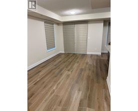 A room with wooden flooring and white walls.