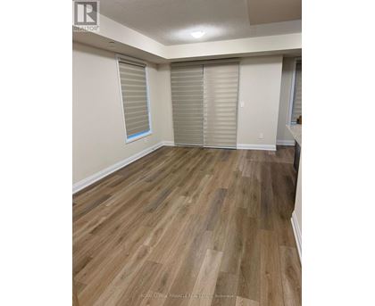 A room with wooden flooring and white walls.