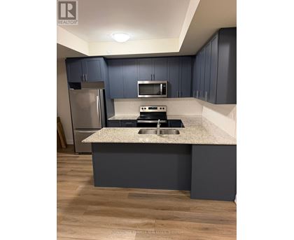 A kitchen with a granite countertop and a refrigerator.