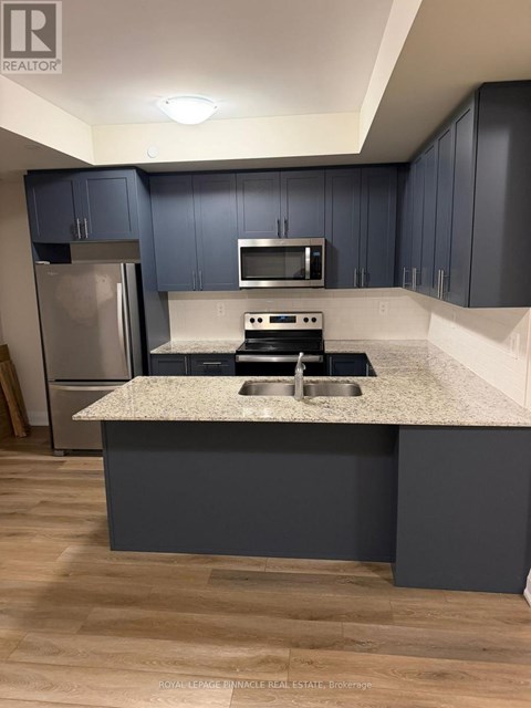 A kitchen with a granite countertop and a refrigerator.