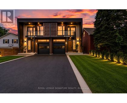 A modern house with a large front yard and a driveway leading to the garage.