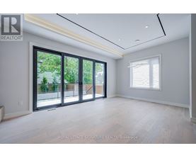 A spacious room with a sliding glass door leading to a balcony.