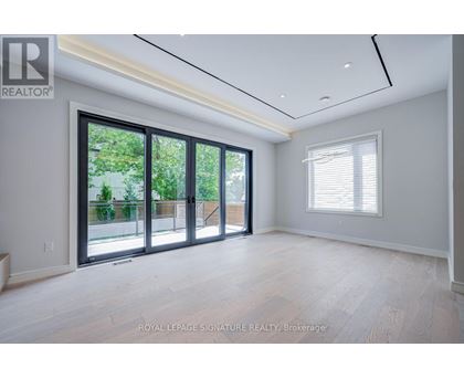 A spacious room with a sliding glass door leading to a balcony.