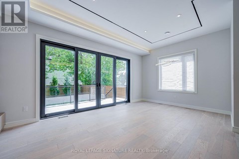 A spacious room with a sliding glass door leading to a balcony.