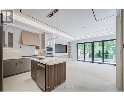 A modern kitchen with a central island and a view of the backyard.