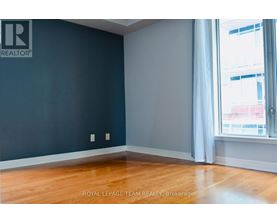 A room with a dark blue wall and wooden flooring.