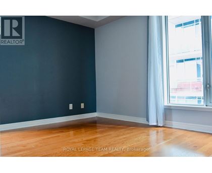 A room with a dark blue wall and wooden flooring.