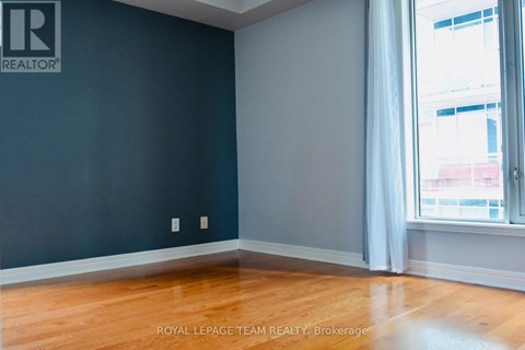 A room with a dark blue wall and wooden flooring.