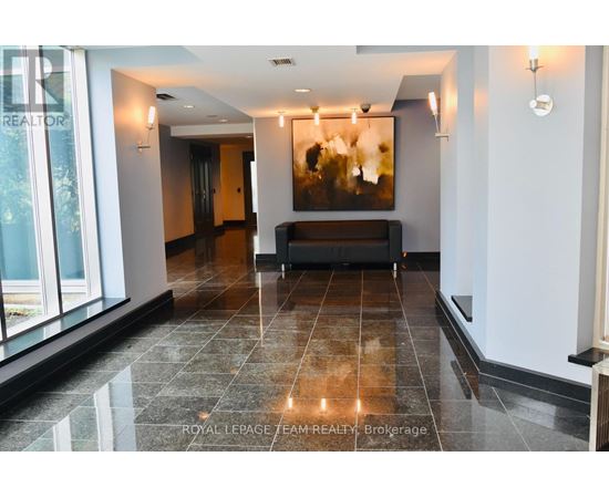 A spacious hallway with a bench and a painting on the wall.