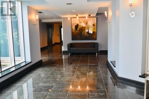 A spacious hallway with a bench and a painting on the wall.