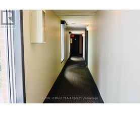 A long hallway with a Royal LePage Team Realty Brokerage sign on the wall.