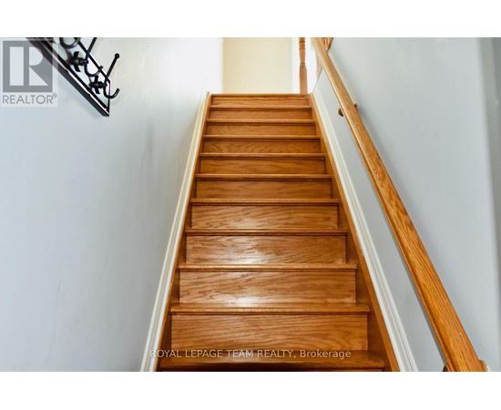 A wooden staircase with a metal handrail.