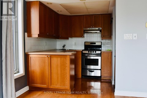 A kitchen with wooden cabinets and a black stove top oven.
