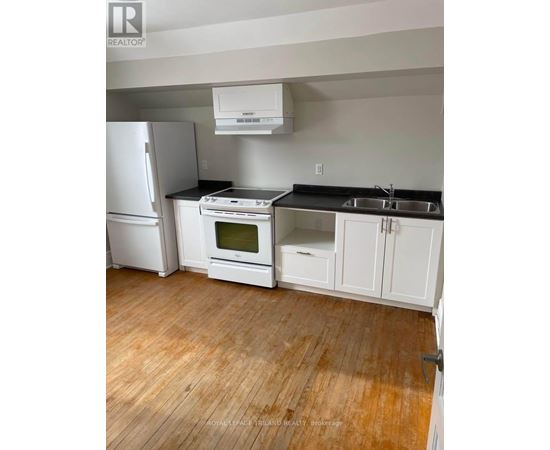 A kitchen with white appliances and cabinets.