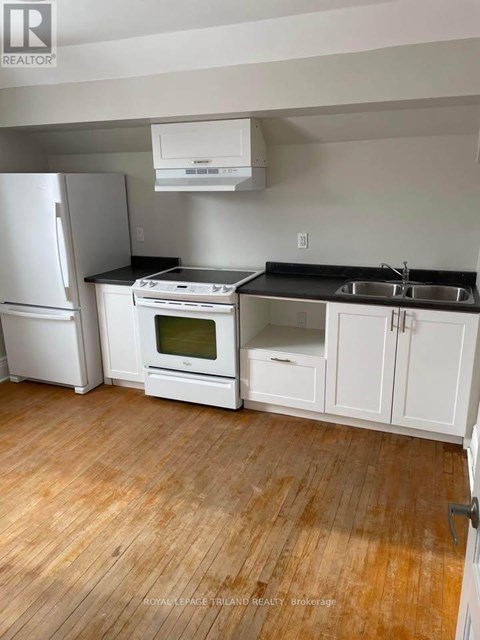 A kitchen with white appliances and cabinets.