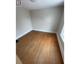 A room with wooden flooring and white walls.