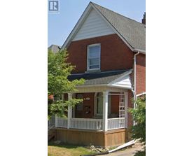 A house with a red brick exterior and a white porch.