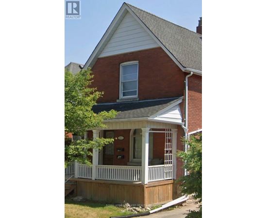 A house with a red brick exterior and a white porch.