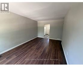 A room with wooden flooring and a white door.