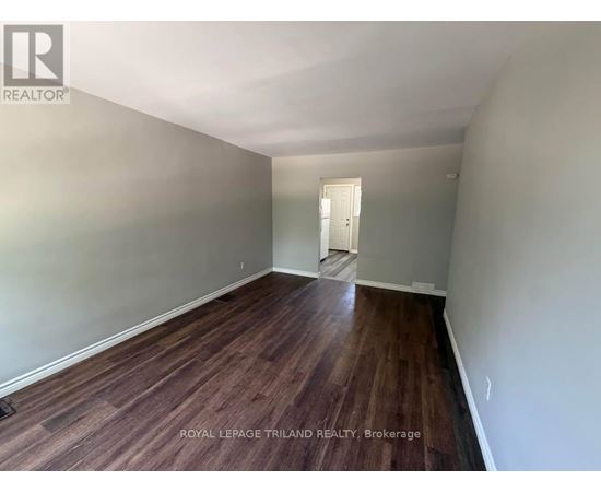 A room with wooden flooring and a white door.