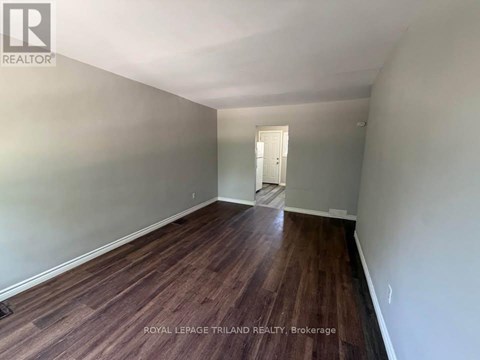 A room with wooden flooring and a white door.
