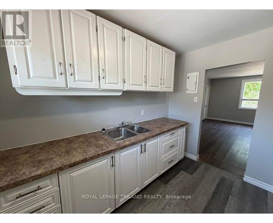 A kitchen with white cabinets and a granite countertop.