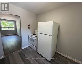 A white refrigerator in a room with a window.
