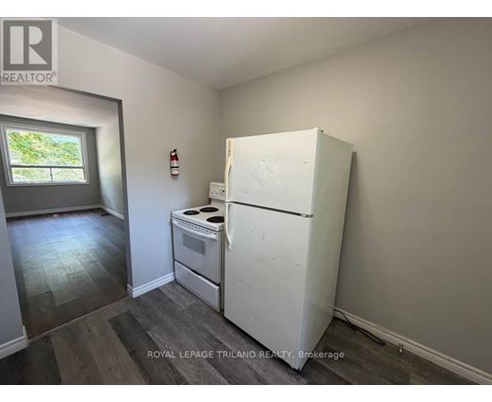 A white refrigerator in a room with a window.