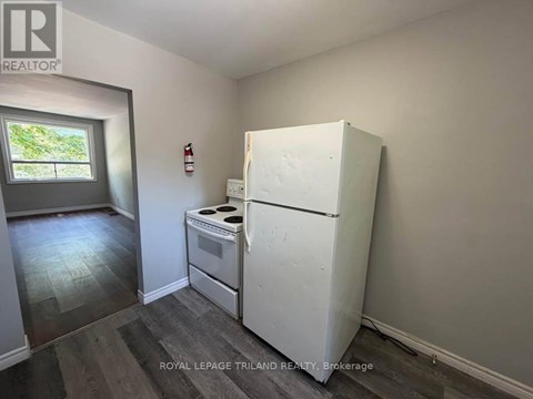 A white refrigerator in a room with a window.