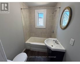 A small bathroom with a toilet, sink and tub.