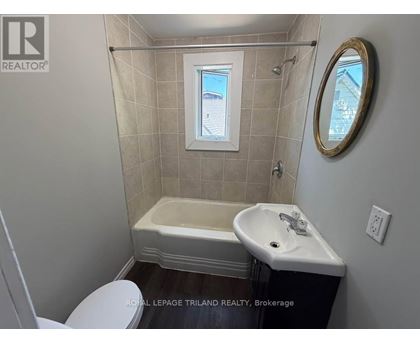 A small bathroom with a toilet, sink and tub.