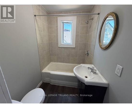 A small bathroom with a toilet, sink and tub.