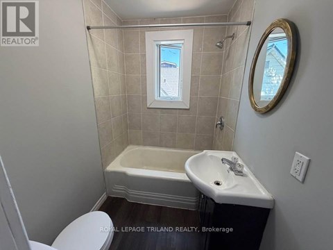 A small bathroom with a toilet, sink and tub.