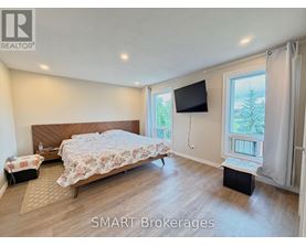 A bedroom with a large bed and a flat screen TV mounted on the wall.