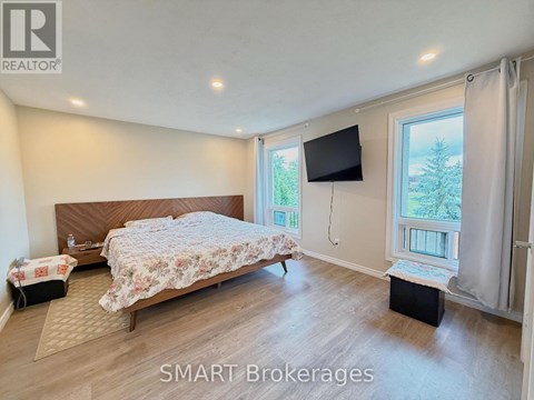 A bedroom with a large bed and a flat screen TV mounted on the wall.