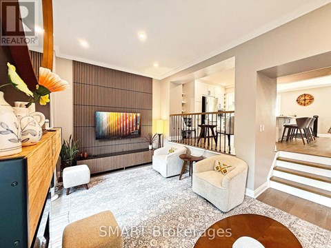A living room with a sofa, a chair, a table, and a painting on the wall.