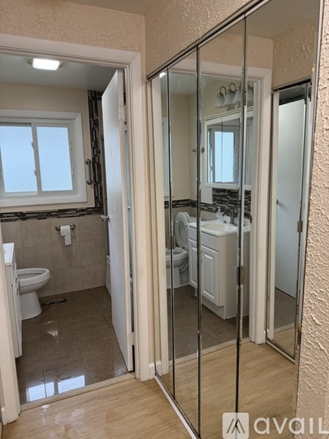 A bathroom with a toilet, sink, and mirror.