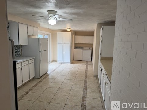 A kitchen with white cabinets and a tiled floor.