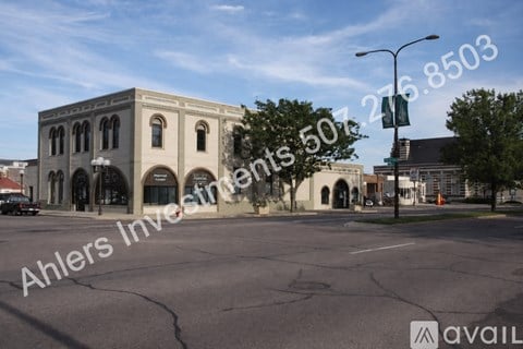 A street view of a building with a car parked in front.