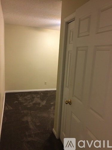 A hallway with a door on the right and a wall on the left.