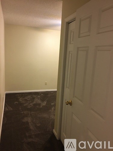 A hallway with a door on the right and a wall on the left.