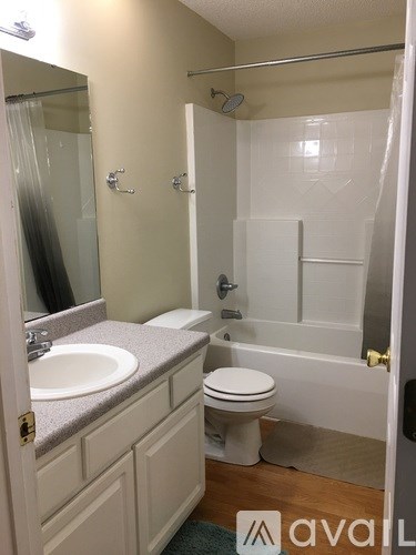 A bathroom with a toilet, sink, and bathtub.