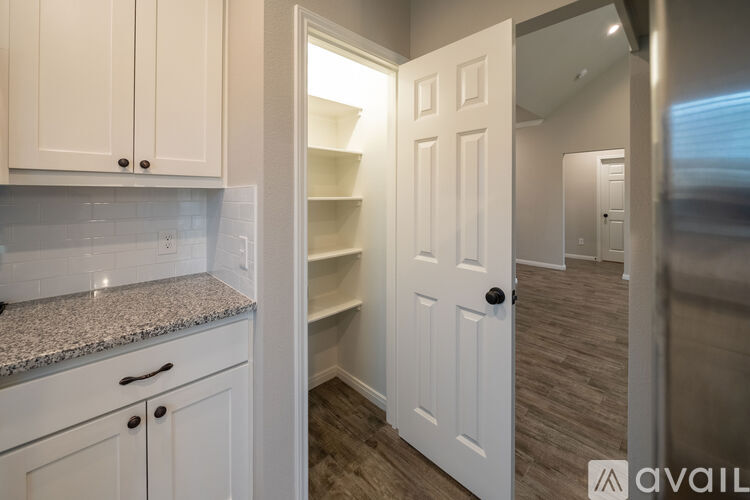 A kitchen with white cabinets and a granite countertop.